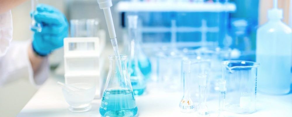 Doctor using electronic pipette for taking samples from test tube in special chemical laboratory or private clinic